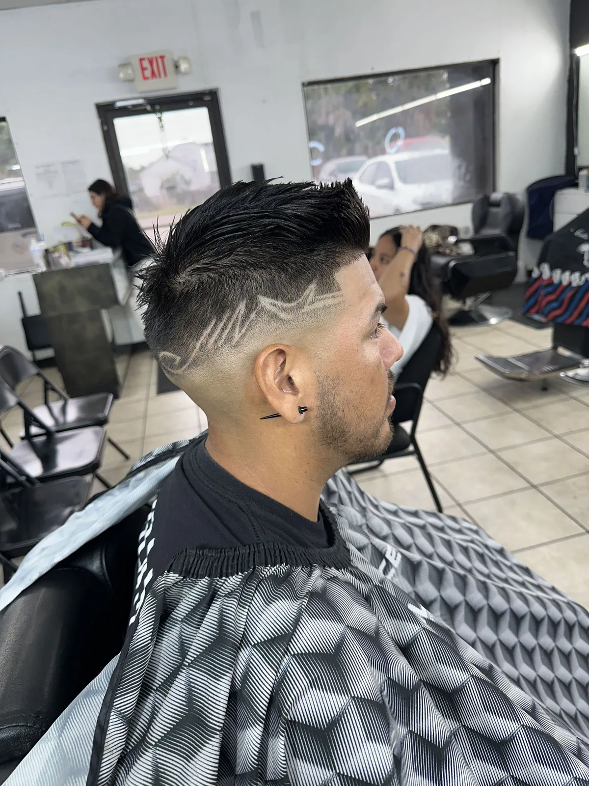 Mohawk fade with a layered freestyle design carved into the side