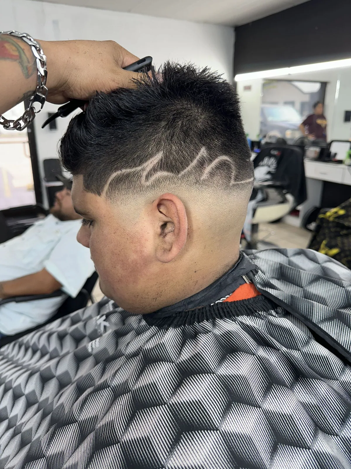 High fade with a bold lightning-inspired line design
